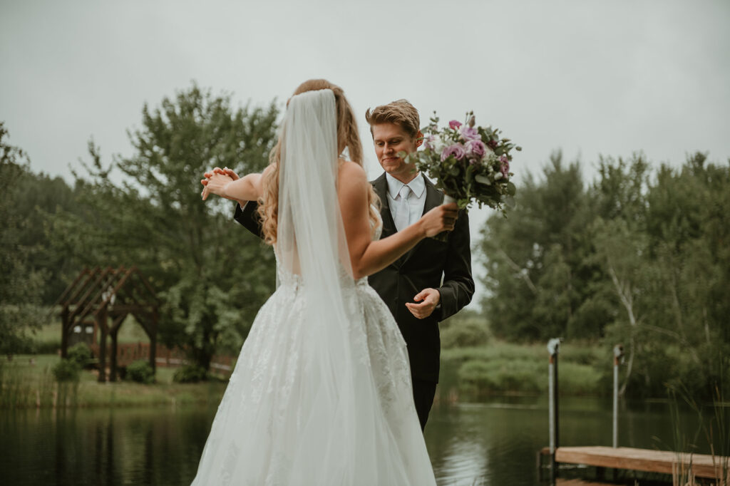 a groom admiring the bride's dress after their first look