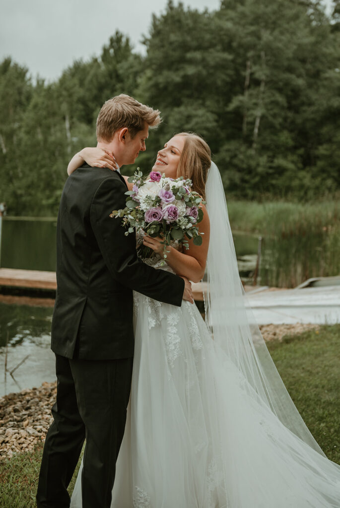 a bride smiling at the groom near a pond at dixons apple orchard