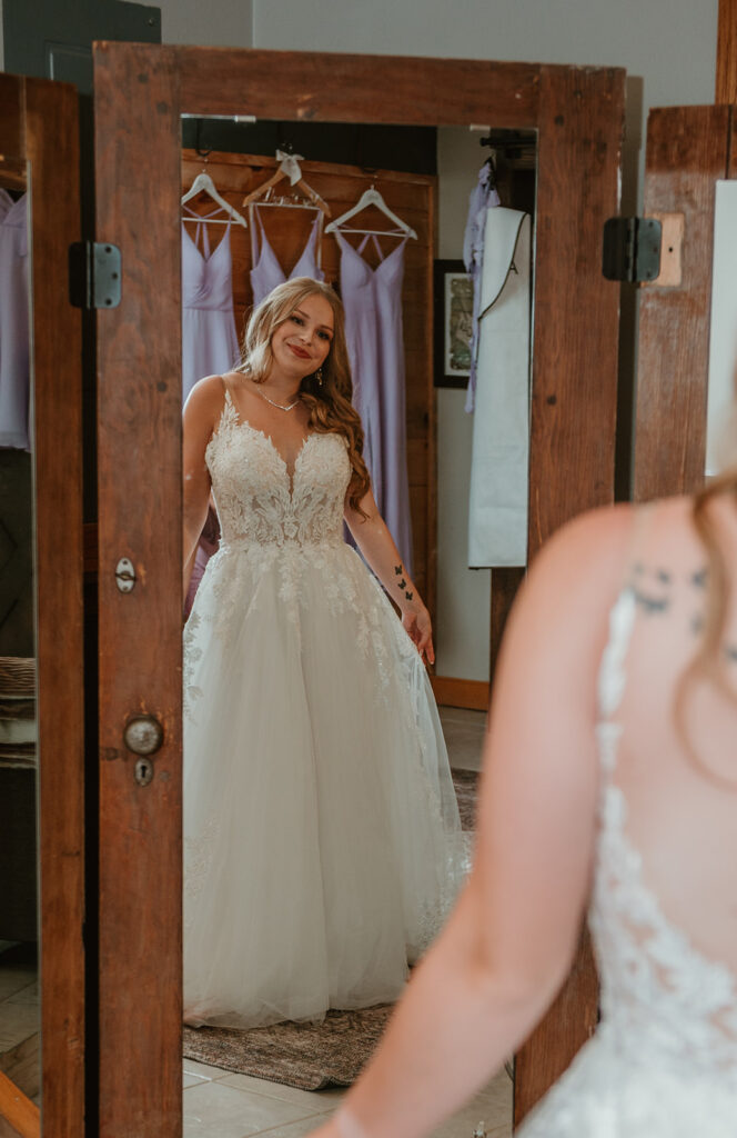 a bride admiring herself in her wedding dress