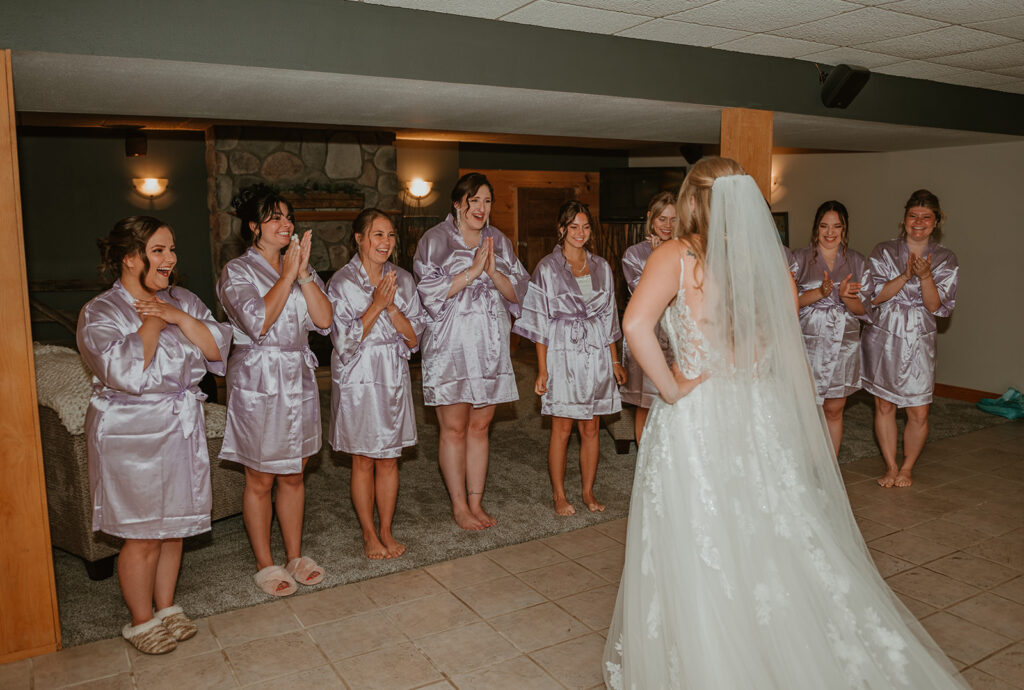 bridesmaids acting excited and happy after seeing the bride for the first time in her wedding dress