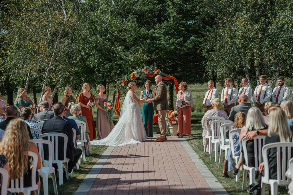 the bride and groom holding hands at the altar