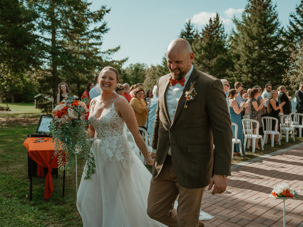 the bride and groom walking back up the isle smiling because they just got married