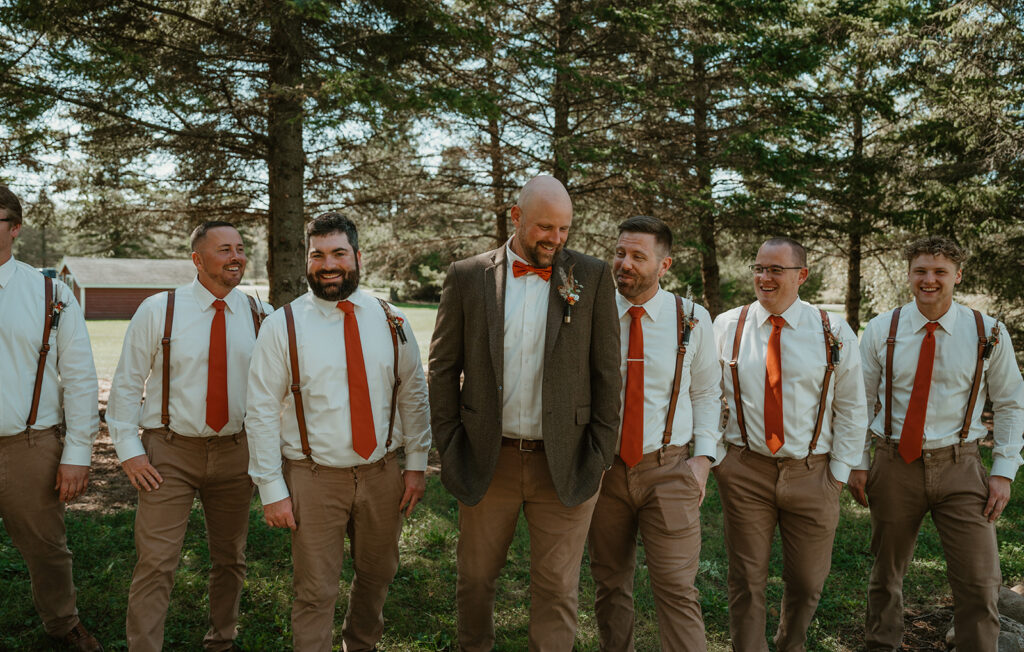 groom walking with his groomsmen in the wooded area at homestead meadows farm