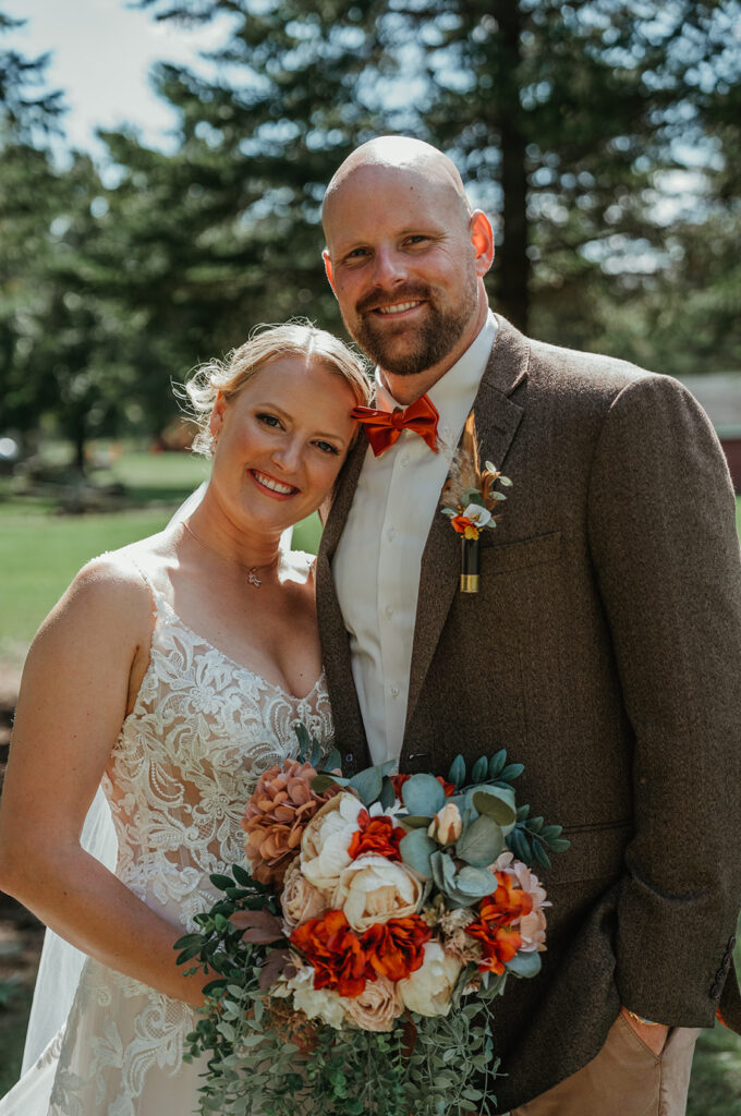 bride and groom smiling at the camera in the wooded area at homestead meadows farm