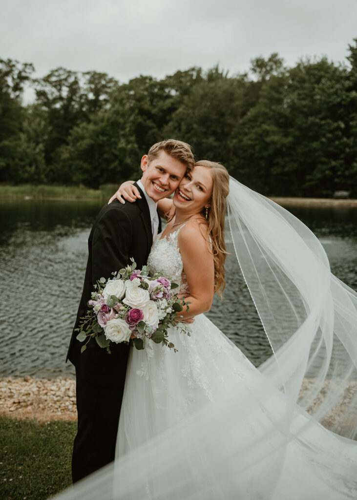 a very happy bride and groom smiling at the camera on their wedding day