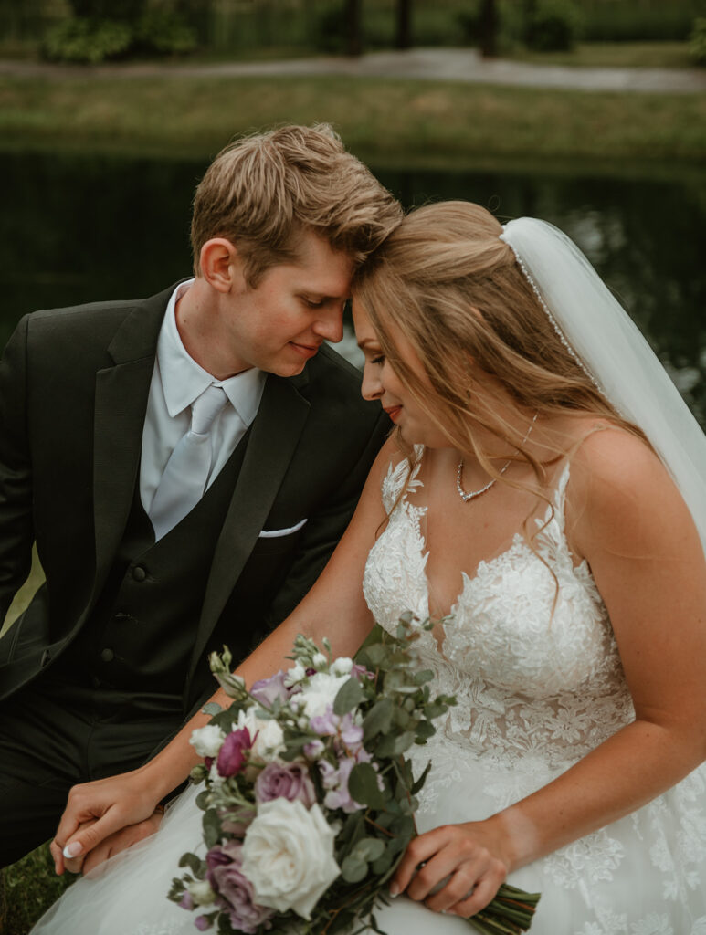 bride and groom resting their foreheads together gently in their wedding attire