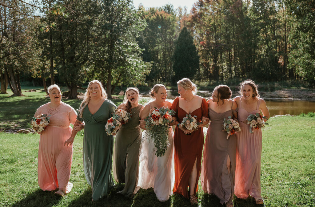 a bride and her bridesmaids walking together while laughing at homestead meadows farm