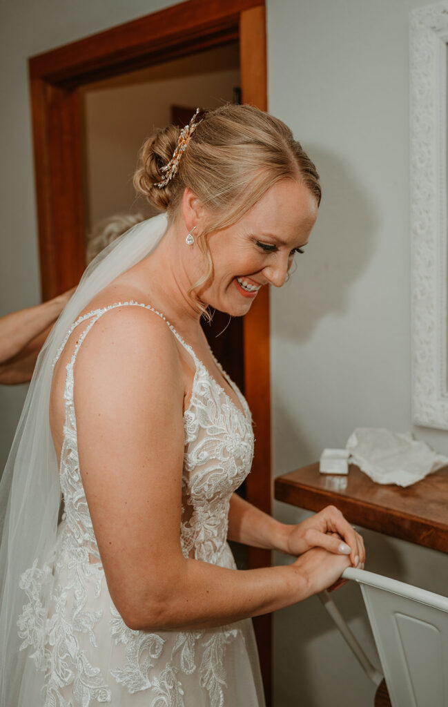 bride is happy she is finished getting ready and about to do a first look with her dad