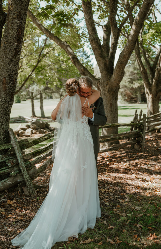 an emotional hug between the bride and her dad on her wedding dayd