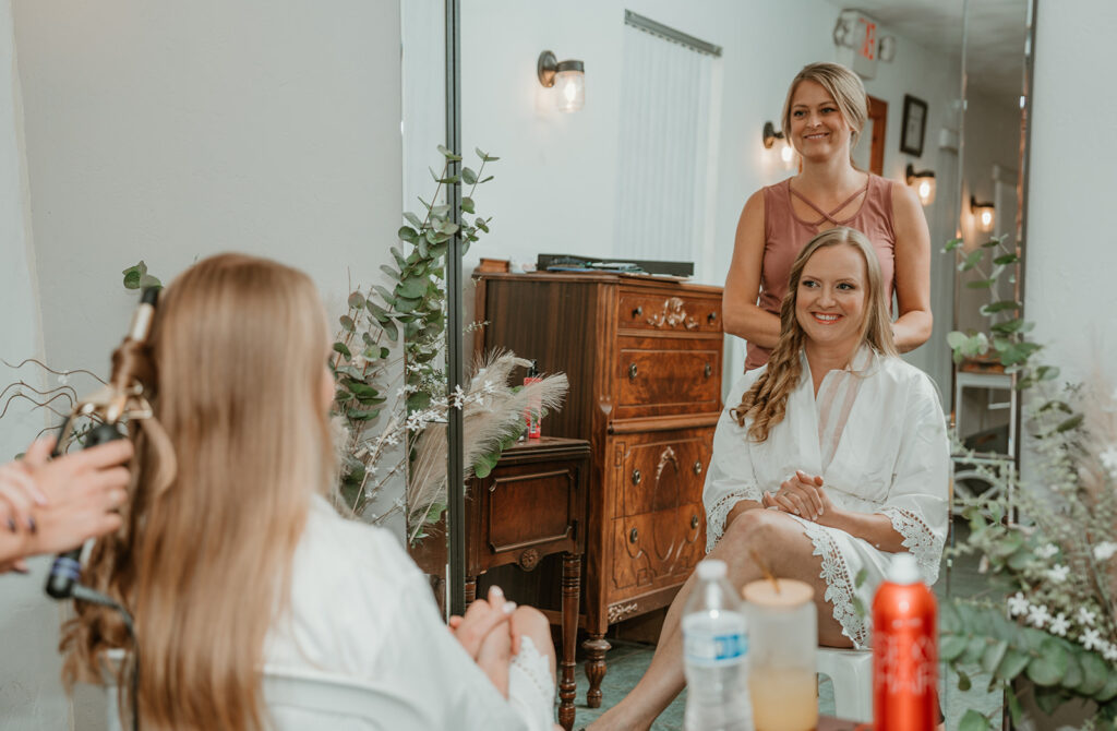 bride getting her hair done by the hairstylist in the bridal suite at homestead meadows