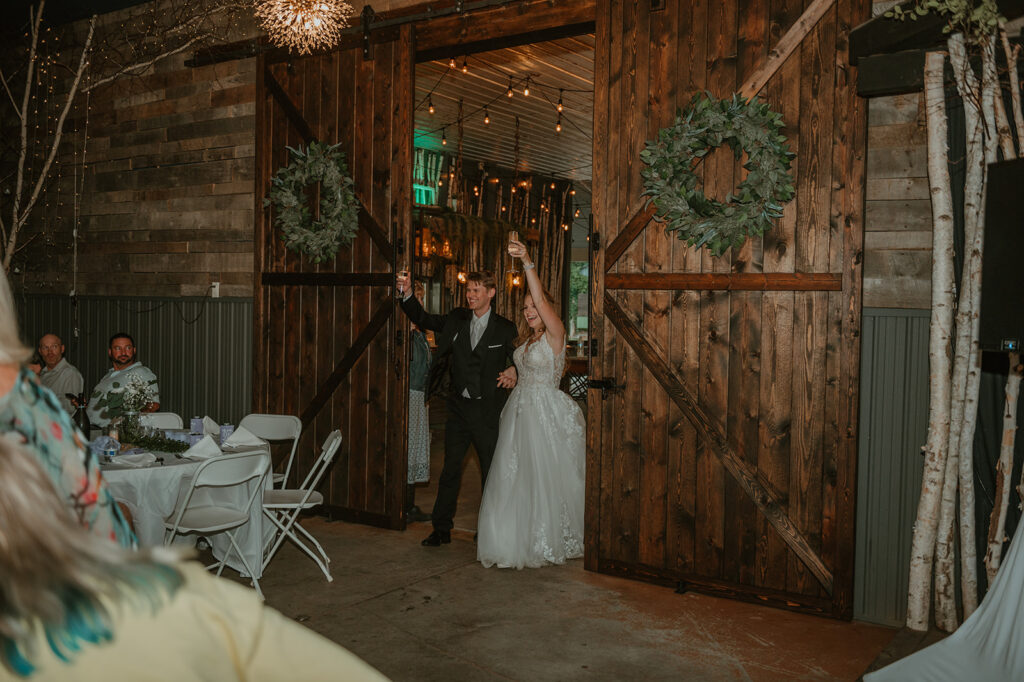 a bride and groom entering the reception at dixons apple orchard in cadott wi