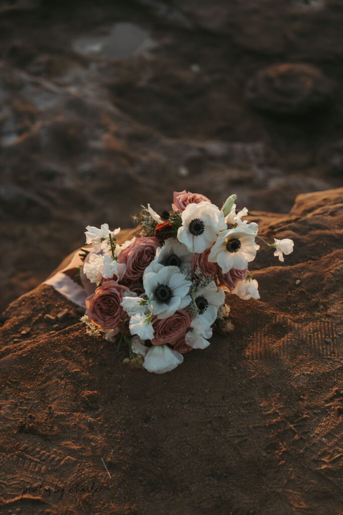 Close-up of a beautiful bridal bouquet with the blurred coastline San Diego elopement details