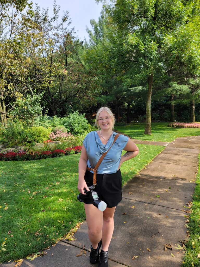 a photographer wearing a single strap harness, a piece of essential wedding photography gear