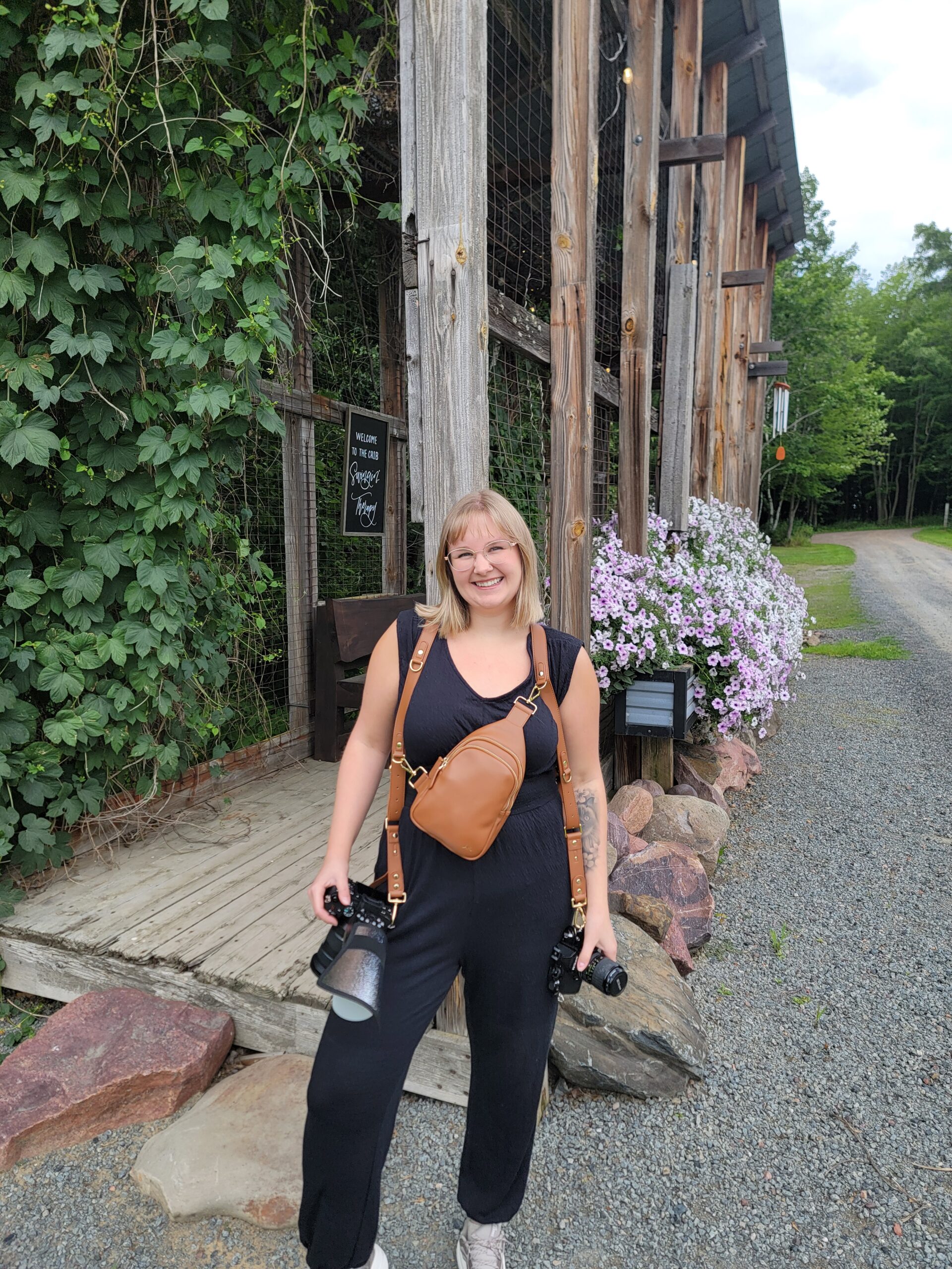 A photographer wearing a dual camera harness, a key piece of essential wedding photography gear for a long day of shooting